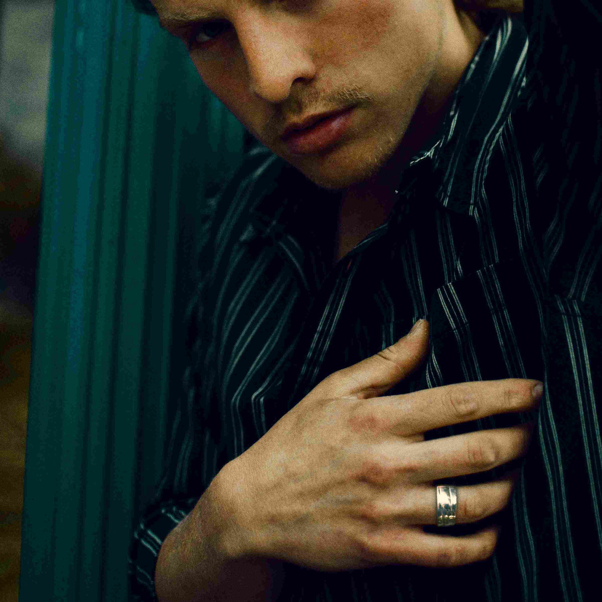 Young male model displaying a wide silver ring