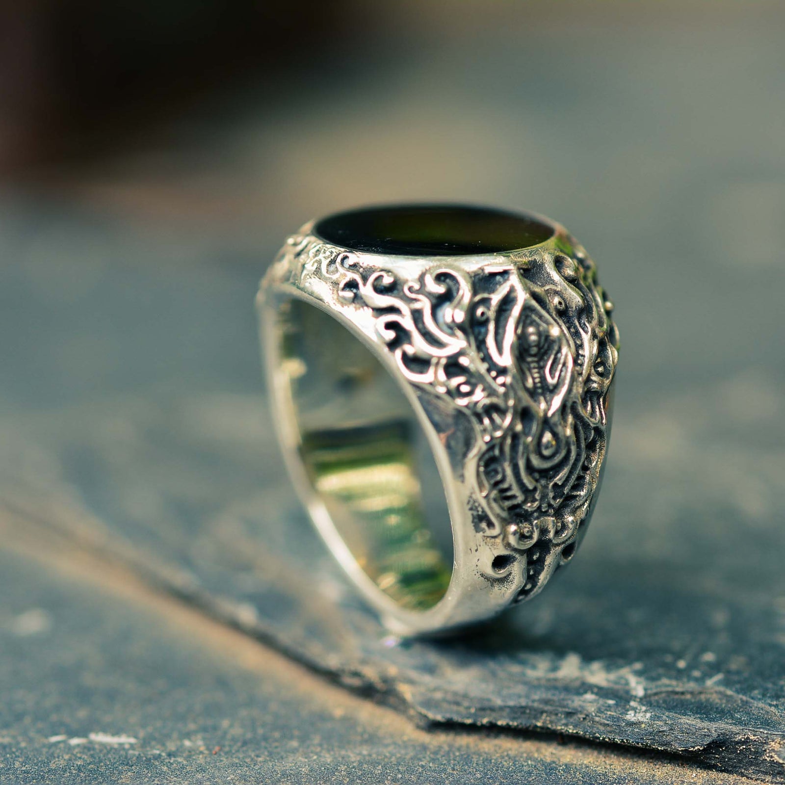 A large and sculpted sterling silver ring with a black hardened resin at the top