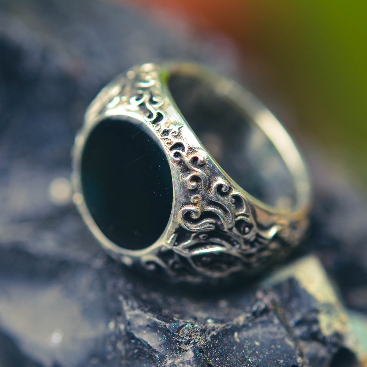 Decorative ring with black stone on a textured surface