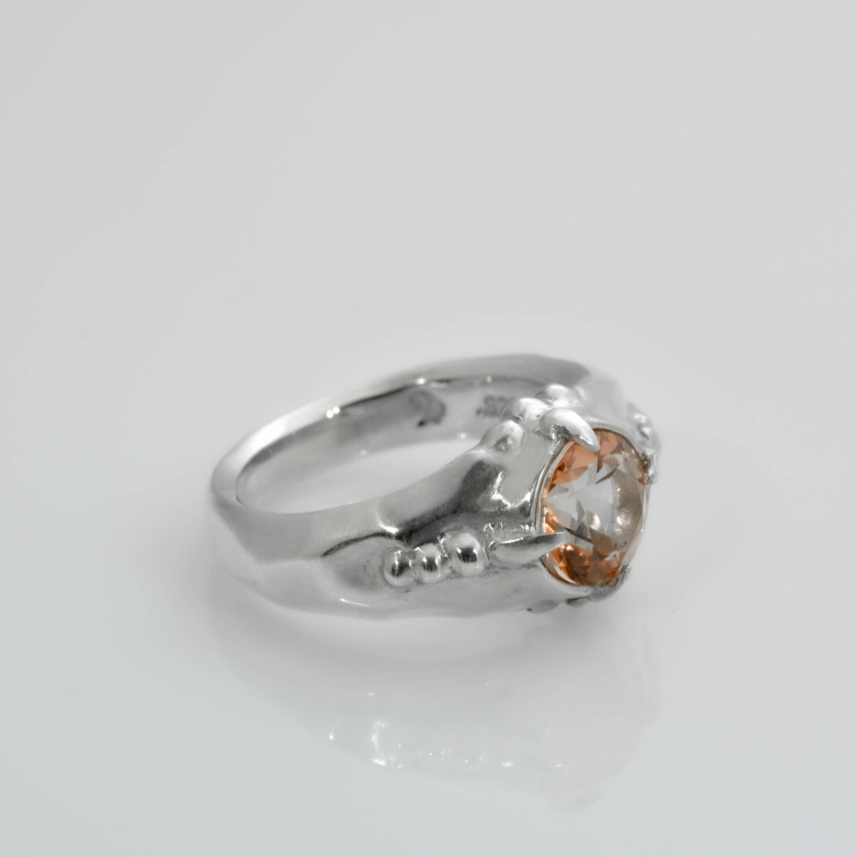 L&#39;anello a quattro angoli ha un design sfaccettato con un topazio arancione