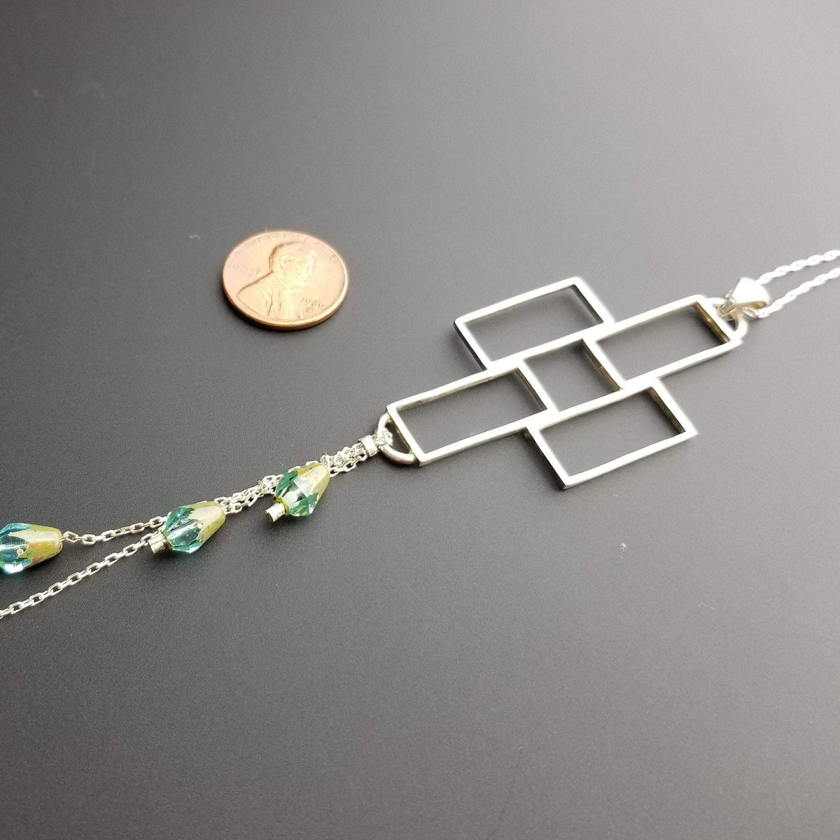 Thin cross pendant and penny comparison